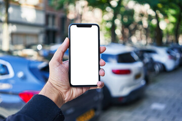 Man holding smartphone showing white blank screen at car parking