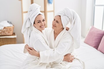 Obraz premium Mother and daughter wearing bathrobe hugging each other at bedroom
