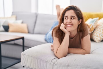 Young woman smiling confident lying on sofa at home