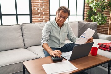 Middle age man working using laptop at home