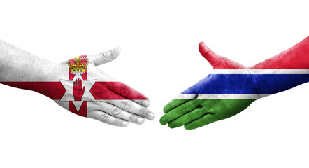 Handshake between Gambia and Northern Ireland flags painted on hands, isolated transparent image.