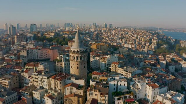 Galata tower in Istanbul, Turkey at sunset. Aerial drone view, European part of city, skyscrapers in background. Downtown of city, most popular sightseeing landmark, tourism concept