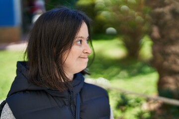 Young woman with down syndrome smiling confident looking to the side at park