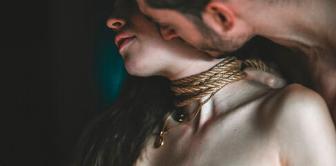 A young, slim, naked hot woman with knots of natural ropes kissed by her boyfriend. Ancient...