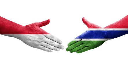 Handshake between Gambia and Monaco flags painted on hands, isolated transparent image.