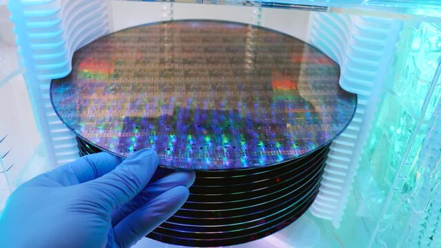 Gloved Hand Holding a Silicon Wafer in plastic holder box