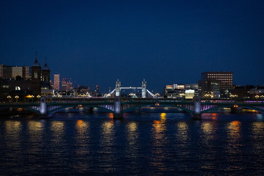 london bridge and skyline at sunset along the thames river