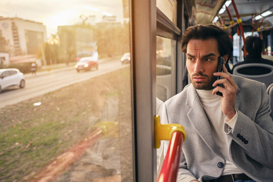 Young Business Man Talking On A Phone While Commuting On A Bus