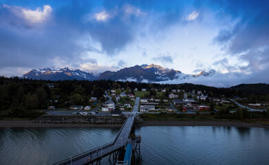Panoramic view of Alaskan Haines town with scenic sunset and dramatic ocean in the background.