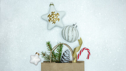 christmas tree decorations with fir branch and cone. christmas shopping bag on silver background.