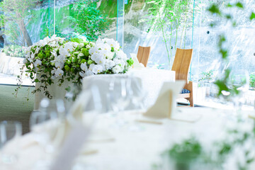 結婚式会場の白いテーブルとワイングラスと花 - obrazy, fototapety, plakaty