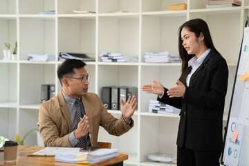 Group of Asian businessman and office workers working in team conference with project planning document on meeting table.