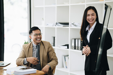 Group of Asian businessman and office workers working in team conference with project planning document on meeting table.