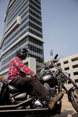 Motorcyclist man with helmet in the city with a building behind