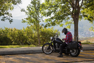 Fototapeta na wymiar Casual man with helmet in his motorcycle on the street