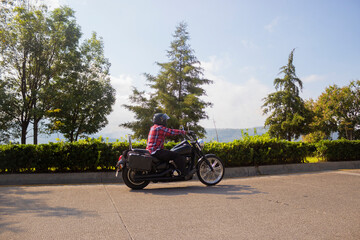 Biker man on a roadtrip with a beautiful vew behind