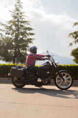 Fototapeta na wymiar Fashion man riding a motorcycle in a sunny day