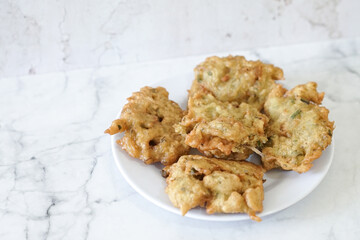 Bakwan goreng, fried food, Indonesian traditional street food snacks. fried vegetables dough fritters, appetizer on a white plate