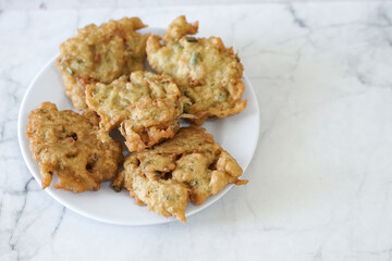 Bakwan goreng, fried food, Indonesian traditional street food snacks. fried vegetables dough fritters, appetizer on a white plate
