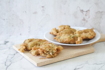Bakwan goreng, fried food, Indonesian traditional street food snacks. fried vegetables dough fritters, appetizer on a white plate