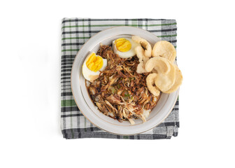 chicken porridge or bubur ayam. Asian style of chicken porridge. topped with shredded chicken, egg and crackers on white bowl and tablecloth. Isolated on white background