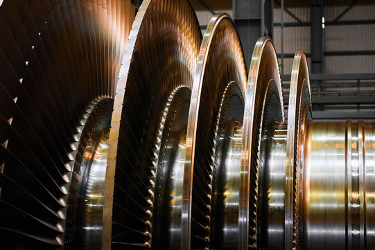 Golden rotor with blade rings of steam turbine in workshop