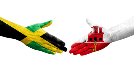 Handshake between Gibraltar and Jamaica flags painted on hands, isolated transparent image.