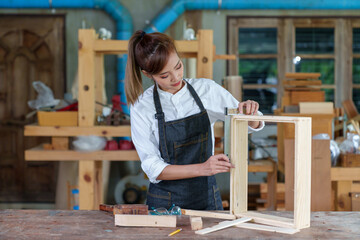 portrait of beautiful asian woman carpenter dealing with handicraft, woman has own business...