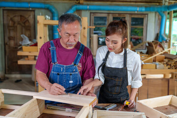 Tutor With Female Carpentry Student In Workshop Studying For Apprenticeship At College ,Teacher explaining a structure students while standing in a woodwork class