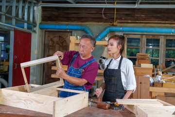 Tutor With Female Carpentry Student In Workshop Studying For Apprenticeship At College ,Teacher explaining a structure students while standing in a woodwork class