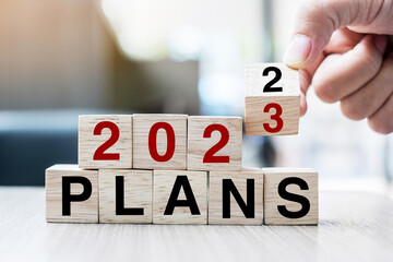 hand flipping block 2022 to 2023 PLAN text on table. Resolution, strategy, goal, motivation,...
