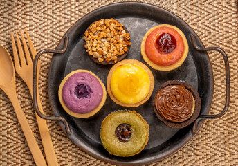 Egg Tart or Baked Cheese Tart in various flavors, purple potato, chocolate, vanilla cream, lemon, green tea and almond cream.