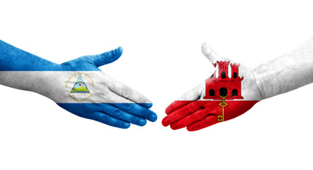 Handshake between Gibraltar and Nicaragua flags painted on hands, isolated transparent image.