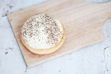 Tiramisu Doughnut Delicious appetizing cake, cream on a white glaze
