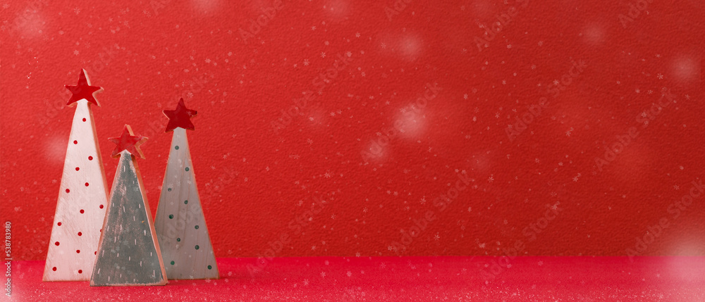 Poster Merry christmas with xmas tree at vivid red wall at wooden table with snow.copy space for adding design