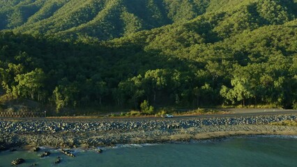 Push In Aerial Drone View Of Professional Athlete Cyclist Riding Bike On Scenic Beachside Coastal Road In Australia, 4K