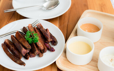Fried sweet purple potato food, fried Japanese purple sweet potato with dips in a wooden tray