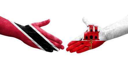 Handshake between Gibraltar and Trinidad Tobago flags painted on hands, isolated transparent image.