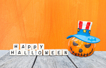 Happy Halloween sign with halloween pumpkin wearing bozo hat with space on orange texture...
