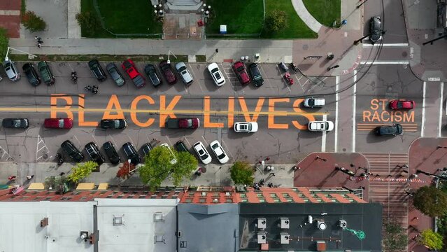 Black Lives Matter. Stop Racism. Letters painted on road in American city. Aerial top down view.