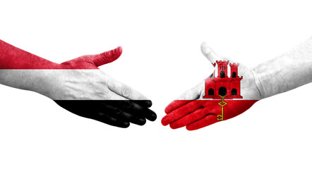 Handshake between Gibraltar and Yemen flags painted on hands, isolated transparent image.