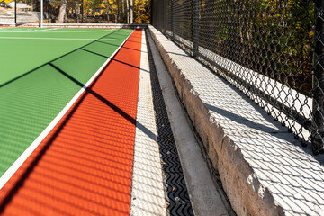 Interesting green and red outdoor basketball court at school playground.  Court includes retaining...