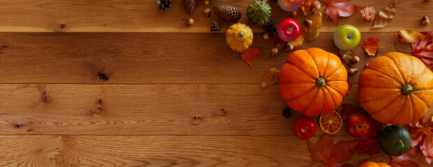 Seasonal Background, with Fall Leaves, Gourds and Berries on a Natural wood Surface. Thanksgiving Concept with space for text.