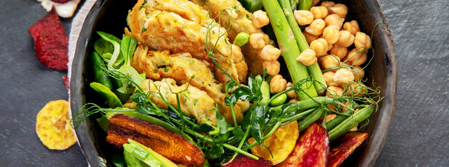 Vegan buddha bowl. Bowl with  vegetables, Zucchini fritters and vegetables chips.