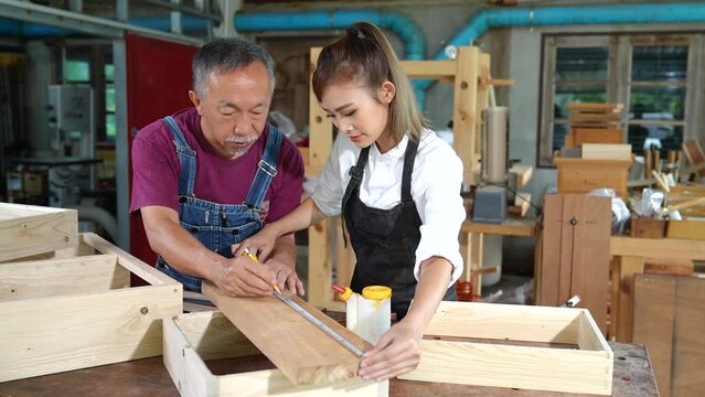 Tutor With Female Carpentry Student In Workshop Studying For Apprenticeship At College ,Teacher explaining a structure students while standing in a woodwork class
