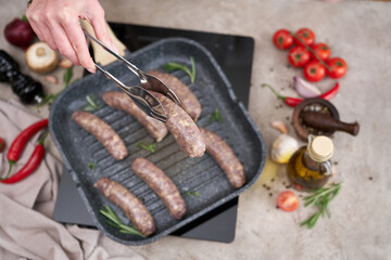 Grilled sausages on a grill frying pan on a domestic kitchen