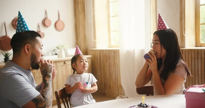 Asian parents inflate balloons for birthday celebration