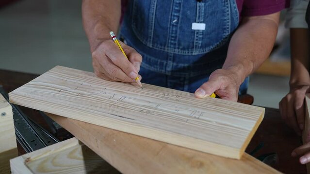 Tutor With Female Carpentry Student In Workshop Studying For Apprenticeship At College ,Teacher explaining a structure students while standing in a woodwork class