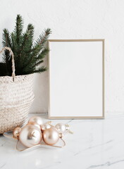 Christmas interior composition with  blank vertical picture frame mockup. Xmas Tree branches in the...