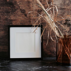 Photo frame mockup and vase with dry grass in loft style interior .Copy space.Dark colors home design.